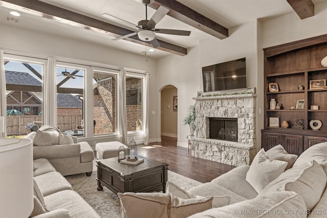 living room featuring light hardwood / wood-style flooring, beam ceiling, a fireplace, and ceiling fan