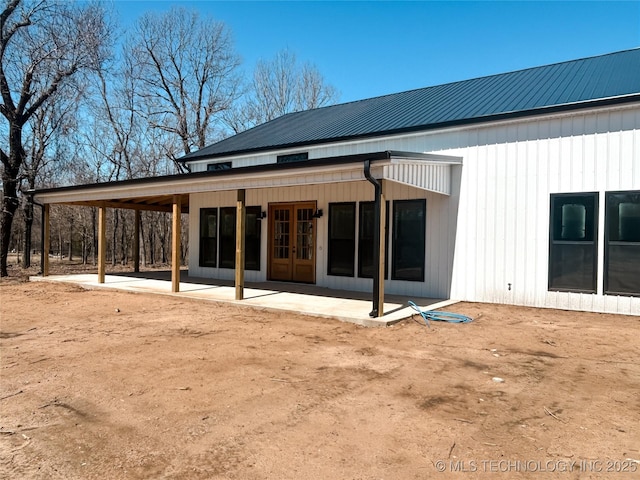 rear view of house with a patio area, french doors, and metal roof