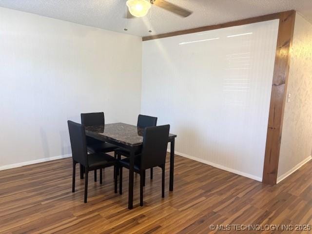 dining area featuring dark wood-type flooring, a textured ceiling, and ceiling fan