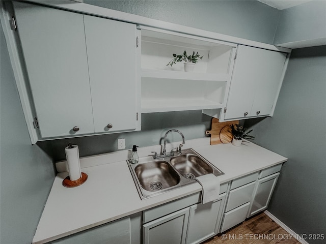 kitchen featuring dark hardwood / wood-style flooring, sink, and white cabinetry