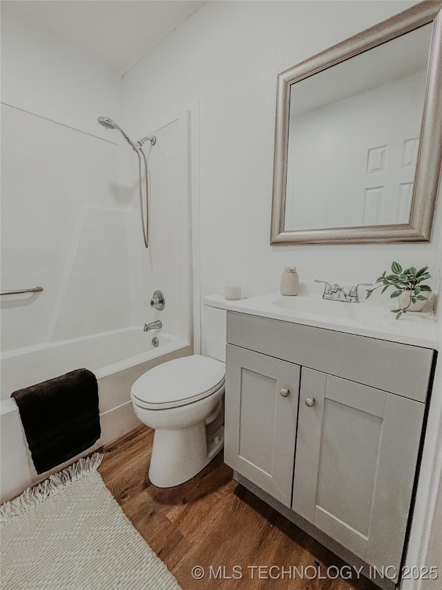 full bathroom featuring hardwood / wood-style flooring, vanity, shower / bathtub combination, and toilet