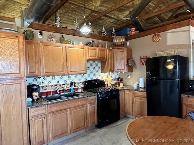 kitchen featuring decorative light fixtures, sink, dark stone countertops, decorative backsplash, and black appliances