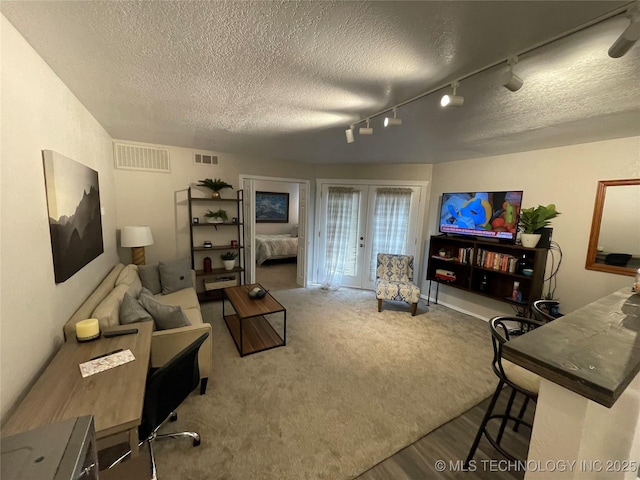 6663 S Victor Ave Unit H # 305, Tulsa, OK 74136 - carpeted living room featuring a textured ceiling, french doors, rail lighting, and wood finished floors