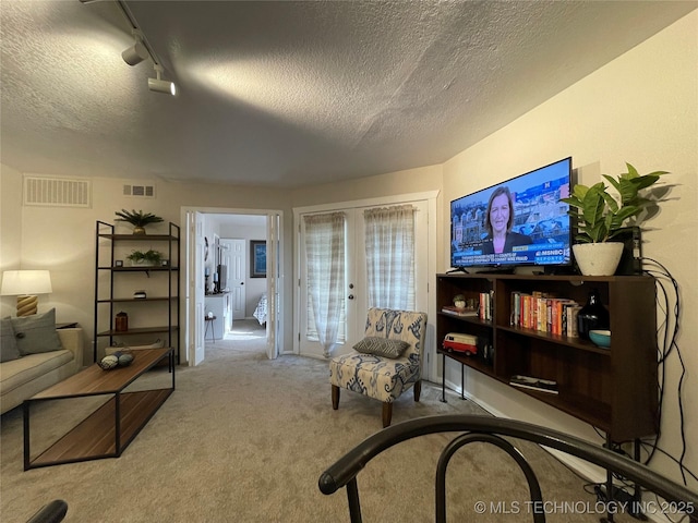 6663 S Victor Ave Unit H # 305, Tulsa, OK 74136 - living room featuring french doors, carpet floors, a textured ceiling, and rail lighting