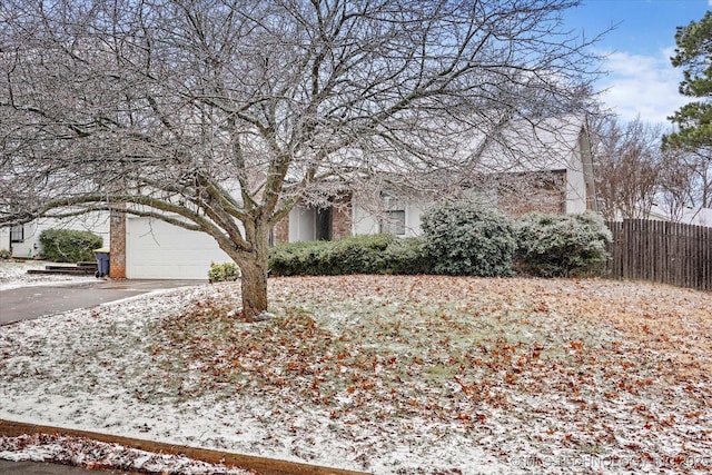 view of property hidden behind natural elements featuring a garage