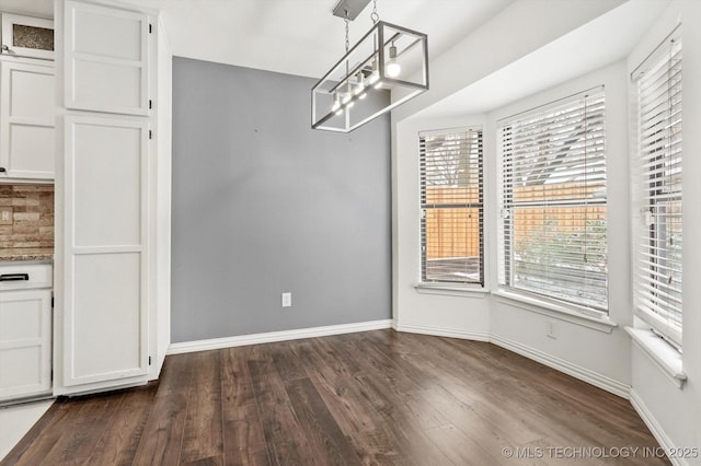 unfurnished dining area featuring dark hardwood / wood-style floors and a notable chandelier