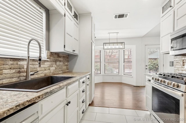 kitchen featuring white cabinetry, appliances with stainless steel finishes, sink, and pendant lighting