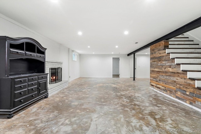 unfurnished living room featuring a brick fireplace, concrete floors, and wood walls