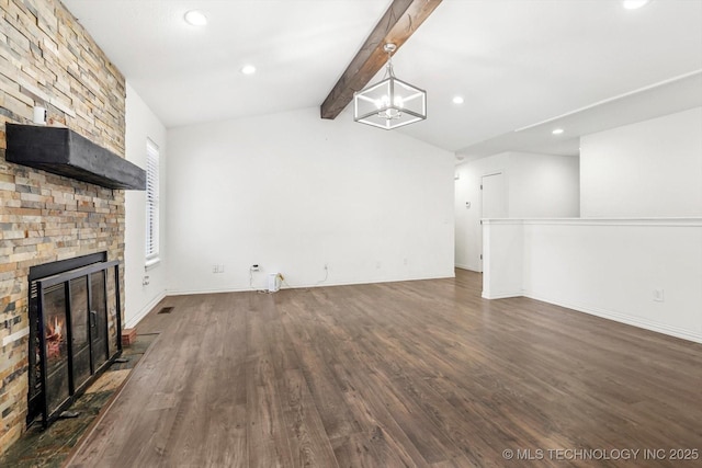 unfurnished living room with vaulted ceiling with beams, dark hardwood / wood-style floors, a notable chandelier, and a large fireplace