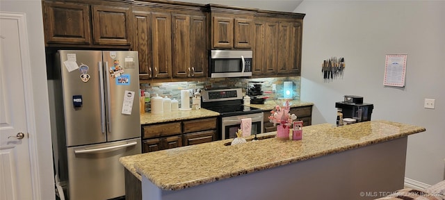 kitchen with light stone counters, tasteful backsplash, stainless steel appliances, and dark brown cabinets