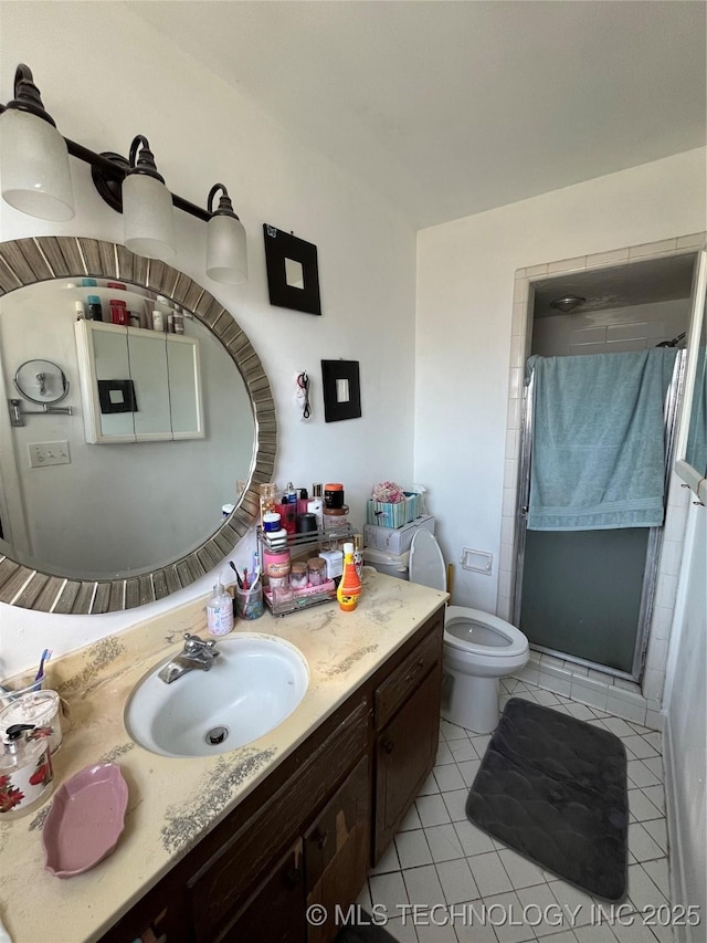 bathroom with vanity, tile patterned flooring, a shower with shower door, and toilet