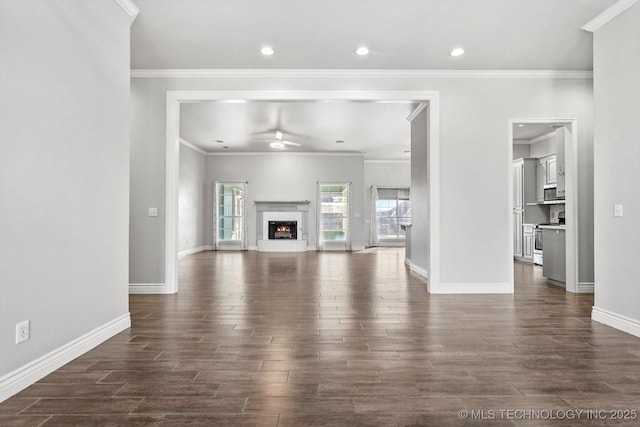 unfurnished living room featuring dark wood-type flooring, ornamental molding, and ceiling fan