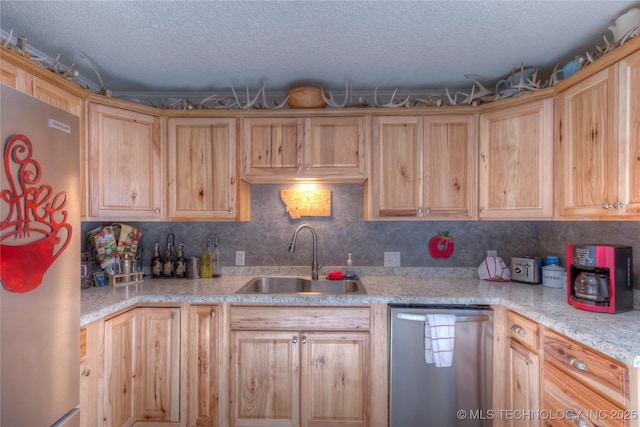 kitchen featuring backsplash, stainless steel appliances, a sink, and light brown cabinetry