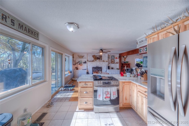 kitchen featuring appliances with stainless steel finishes, light countertops, a peninsula, and light brown cabinets