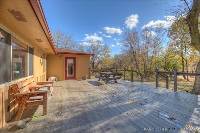 wooden terrace featuring visible vents and outdoor dining space