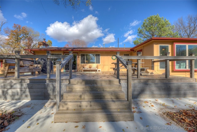 back of property featuring a deck