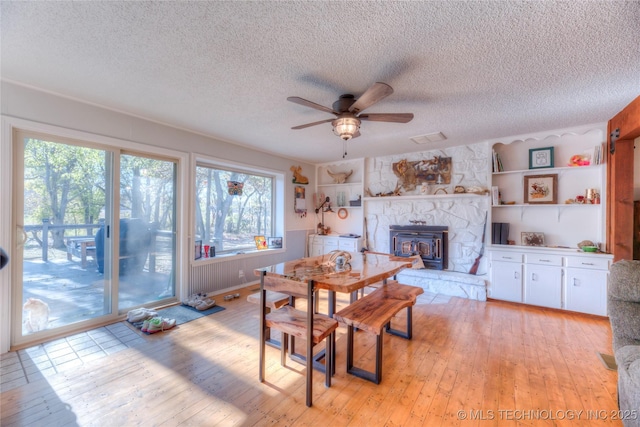 dining room with light wood-style flooring, a textured ceiling, and a ceiling fan