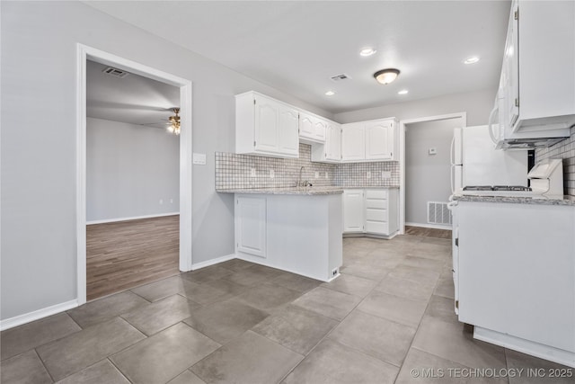 kitchen with light stone counters, tasteful backsplash, light tile patterned floors, ceiling fan, and white cabinets