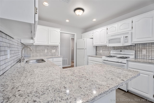 kitchen featuring sink, backsplash, white cabinets, and white appliances