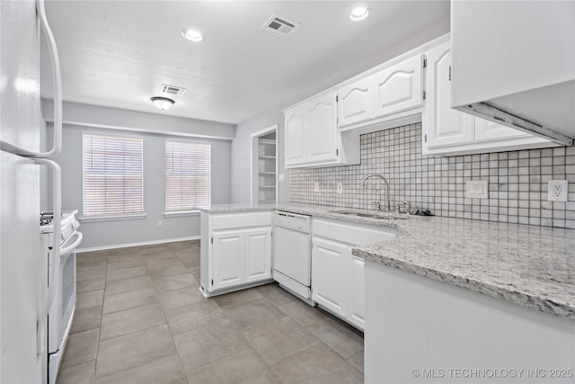 kitchen featuring light stone counters, sink, white appliances, and white cabinets