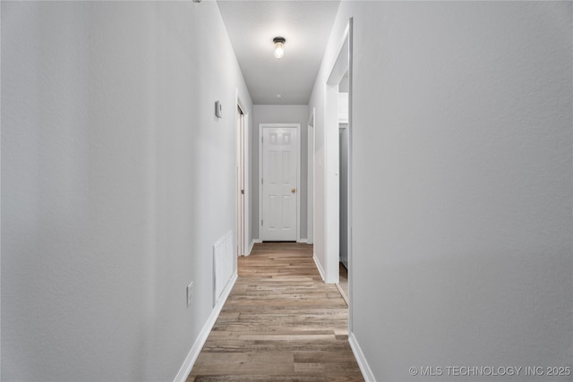 corridor with light hardwood / wood-style flooring