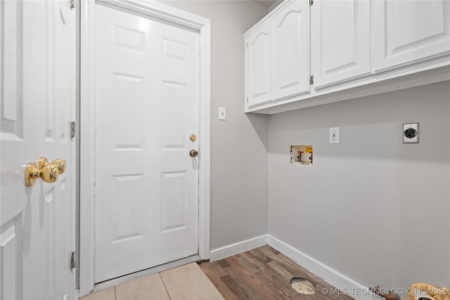 clothes washing area featuring washer hookup, light hardwood / wood-style floors, cabinets, and hookup for an electric dryer