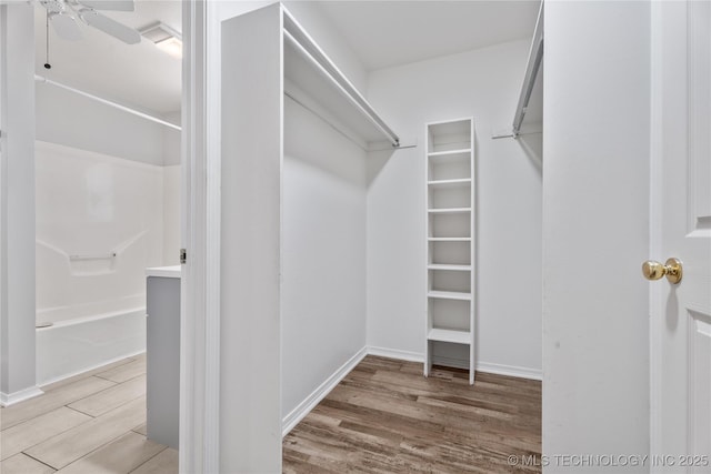 walk in closet featuring ceiling fan and light hardwood / wood-style flooring