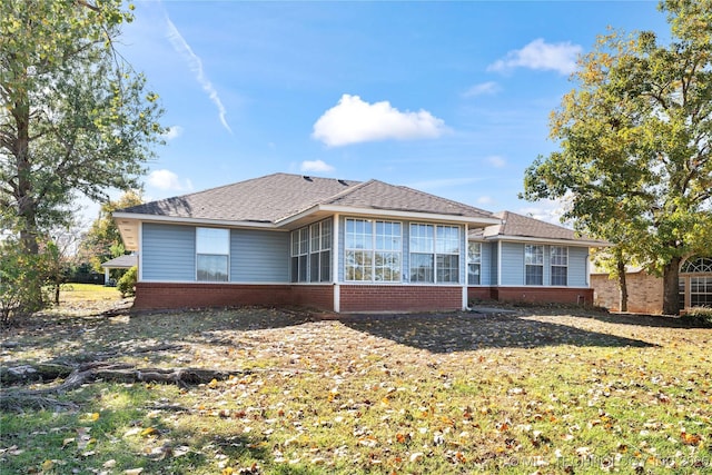 back of property with a lawn and a sunroom