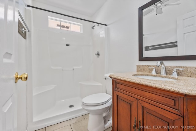 bathroom featuring tile patterned floors, toilet, vanity, and a shower