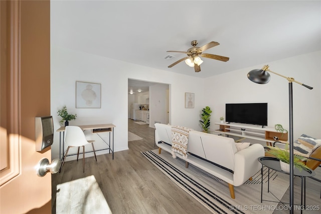 living room featuring ceiling fan and light hardwood / wood-style flooring