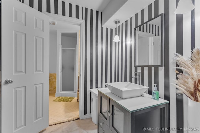 bathroom featuring a shower with door and vanity