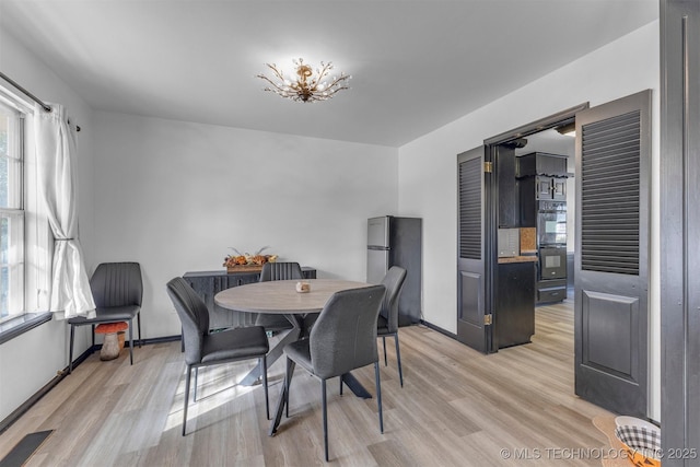 dining room with light wood-type flooring and a wealth of natural light