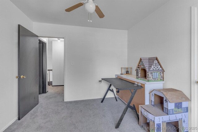 carpeted home office featuring ceiling fan