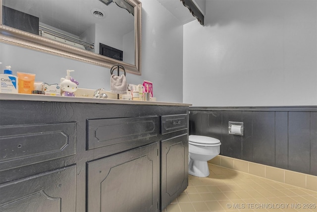 bathroom featuring tile patterned flooring, vanity, and toilet