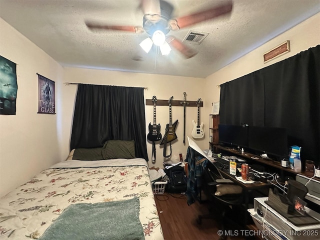 bedroom featuring ceiling fan, hardwood / wood-style floors, and a textured ceiling