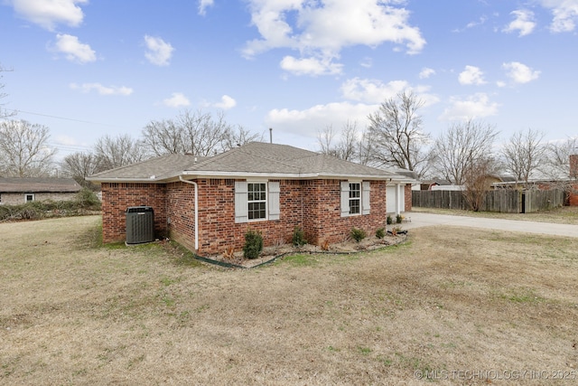 view of front of property with a front yard and central air condition unit