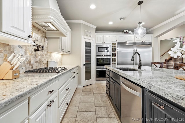 kitchen with premium range hood, white cabinetry, built in appliances, light stone counters, and ornamental molding