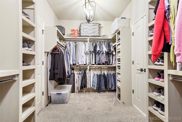 walk in closet with carpet flooring and a notable chandelier