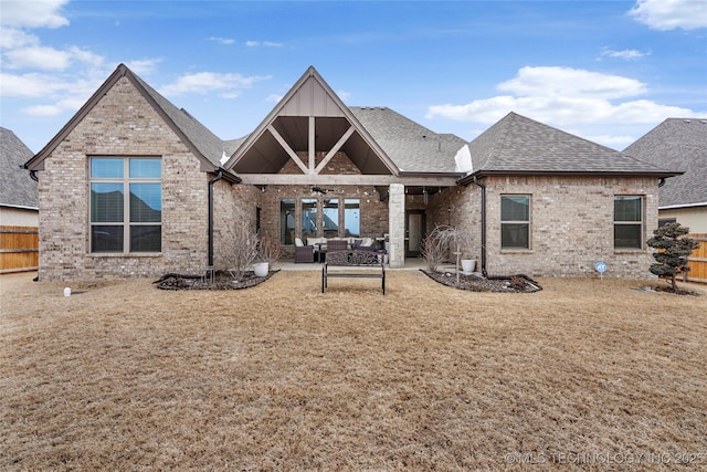 rear view of house with a patio, outdoor lounge area, and a lawn