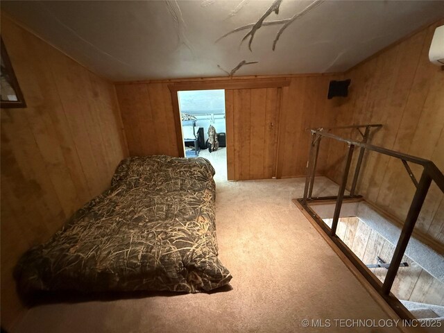 carpeted bedroom featuring wooden walls and a wall mounted air conditioner