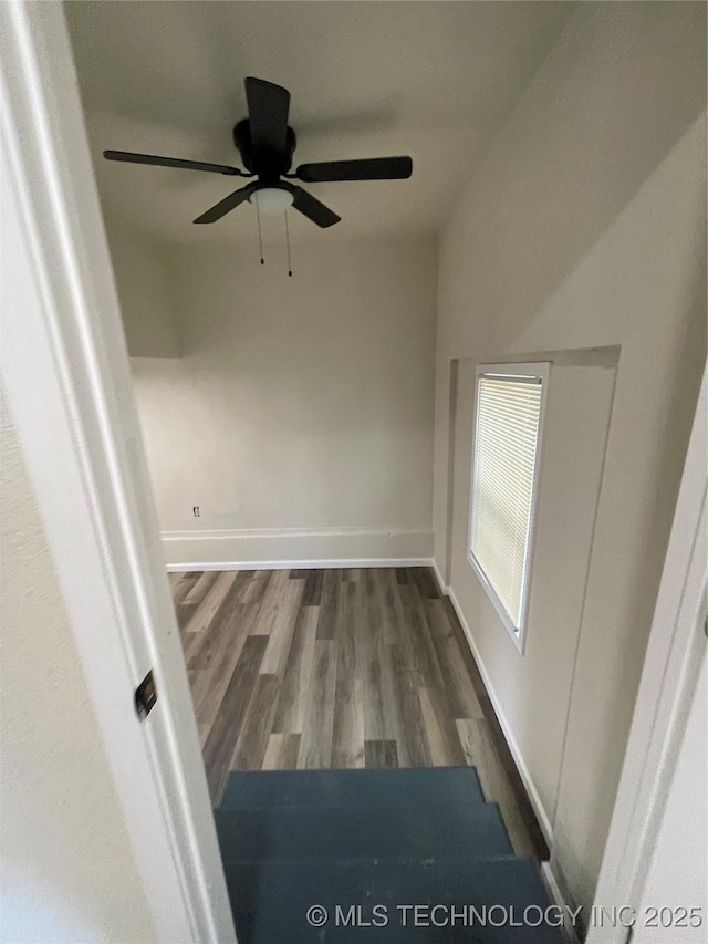 unfurnished room featuring dark wood-style flooring and baseboards