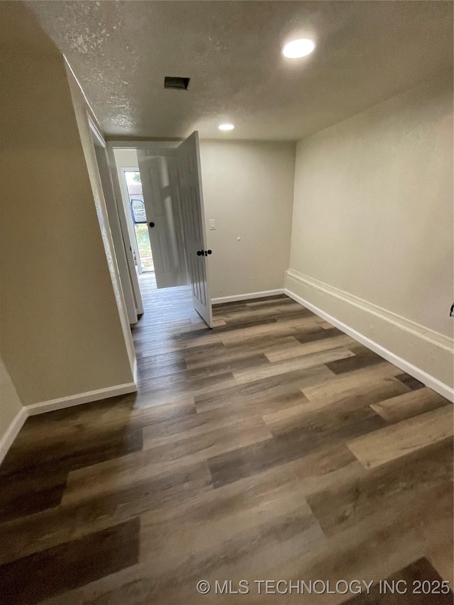 spare room with recessed lighting, visible vents, a textured ceiling, wood finished floors, and baseboards