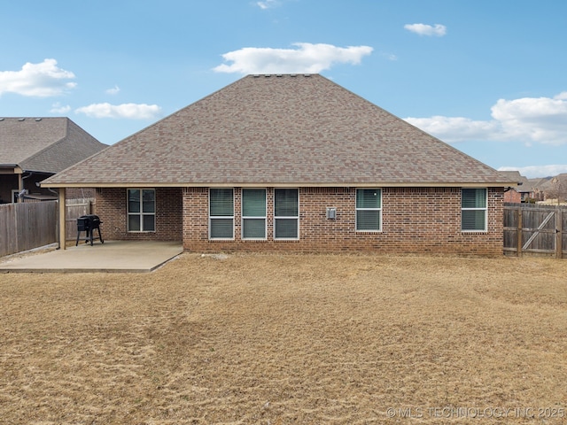 rear view of house with a patio and a lawn