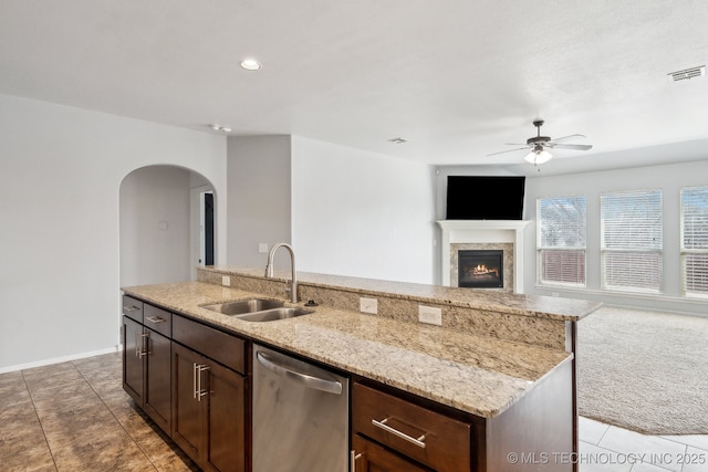 kitchen with an island with sink, sink, stainless steel dishwasher, dark brown cabinets, and ceiling fan