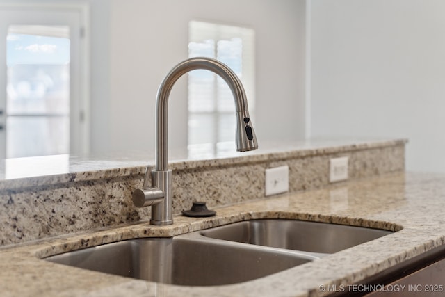 interior details with sink and light stone countertops