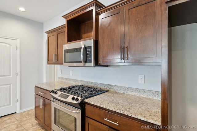 kitchen featuring stainless steel appliances, light stone counters, and light tile patterned floors