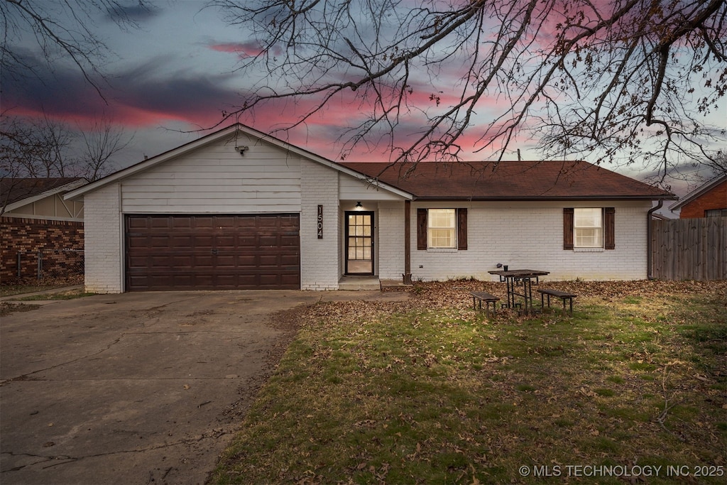 ranch-style house with a garage and a yard