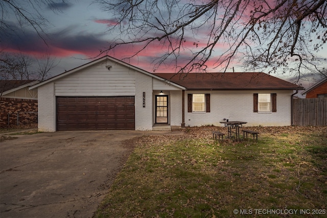 ranch-style house with a garage and a yard