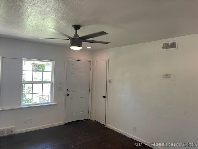 entrance foyer with ceiling fan, a textured ceiling, and dark hardwood / wood-style flooring