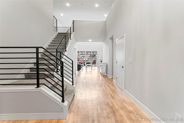 interior space with a towering ceiling and wood-type flooring